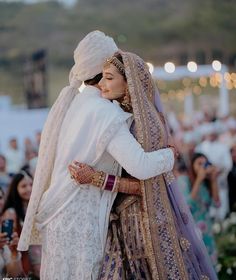 two people hugging each other in front of a crowd