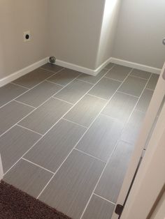 an empty bathroom with gray tile floors and white walls