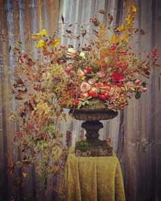 a vase filled with lots of flowers on top of a table