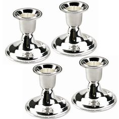 four silver candlesticks sitting on top of each other