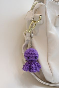 a crocheted keychain hanging from a white purse