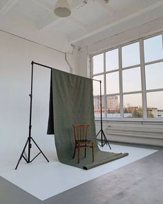 an empty room with two chairs and a backdrop