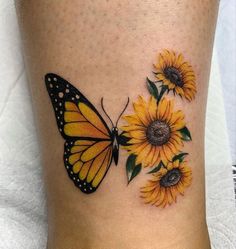 a yellow butterfly with sunflowers on the side of a woman's leg