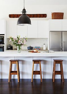 three stools sit in front of the kitchen island