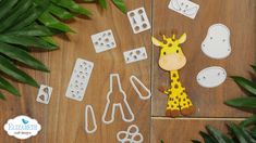 a giraffe cut out from paper next to some plants