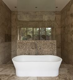 a bath tub sitting inside of a bathroom next to a window