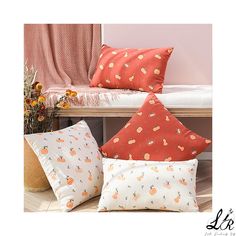 three pillows sitting on top of a wooden bench next to a vase filled with flowers