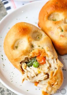 two chicken pot pies on a plate with one cut in half to show the filling