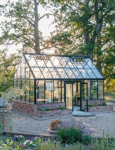 a glass house in the middle of a garden