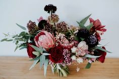 a bouquet of flowers sitting on top of a wooden table