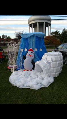 an inflatable snowman is sitting on the grass near a building and net