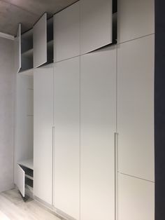 an empty room with white cupboards and shelves