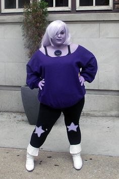 a woman in purple is standing on the sidewalk