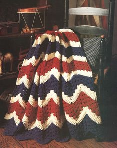 an old fashioned blanket is sitting on a chair