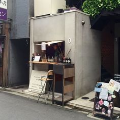 a small bar on the side of a street next to a building with an open door