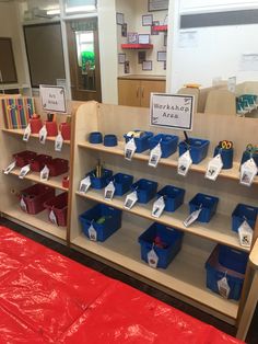 the shelves are filled with books and plastic bins for children's workbench