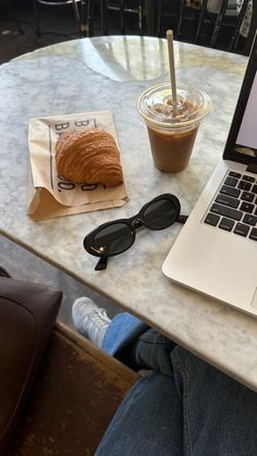 an open laptop computer sitting on top of a table next to a cup of coffee