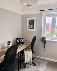 a desk with a laptop on it next to a window