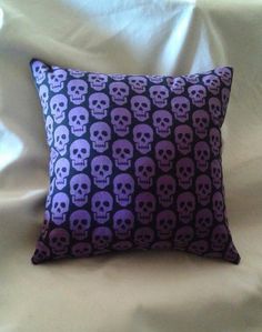 a purple and black pillow with skulls on it