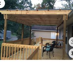 an outdoor covered patio with chairs and table on the back deck, next to a mobile home