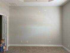 an empty room with two children looking at the ceiling and one is holding a teddy bear