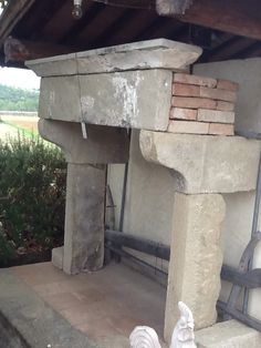 a stone fire place sitting under a roof