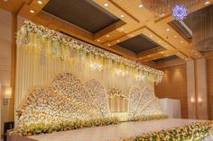 an elaborate stage set up with flowers and chandeliers for a wedding or reception