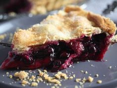 a piece of pie on a plate with crumbled crust and blueberry topping