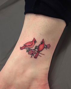 a small tattoo on the foot of a woman with two birds sitting on a branch