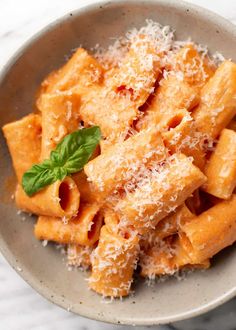 pasta with parmesan cheese and basil in a bowl