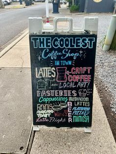 a chalkboard sign on the side of a road advertising coffee shops and eateries