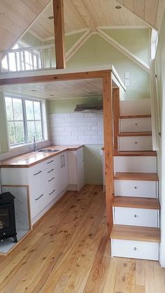 an empty kitchen with stairs leading up to the loft