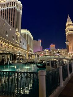 the las vegas hotel and casino is lit up at night with boats in the water