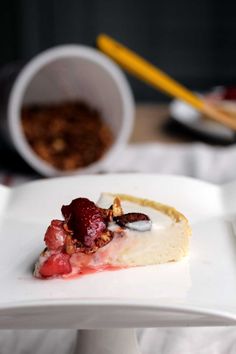 a piece of pie with strawberries and cream on it sitting on a white plate