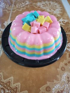 there is a cake that has been decorated with pastel icing and cubes