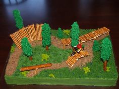 a cake made to look like a small park with trees and logs on the ground