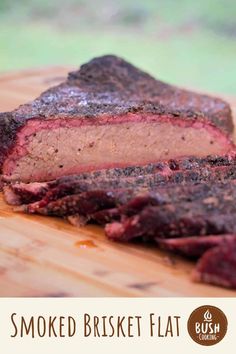 a piece of meat sitting on top of a wooden cutting board with the words smoked brisket flat