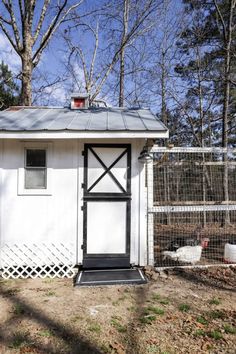 a small white shed with a metal roof