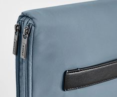 an empty blue bag with a black leather handle and zipper on the front, close up