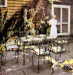 an old photo of a woman standing in the back yard