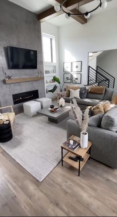 a living room filled with lots of furniture and a flat screen tv mounted above the fireplace