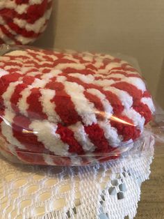 a red and white cake sitting on top of a table next to a glass container