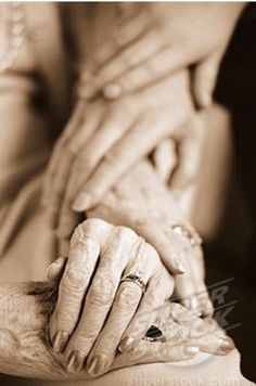 an old woman holding the hands of another person