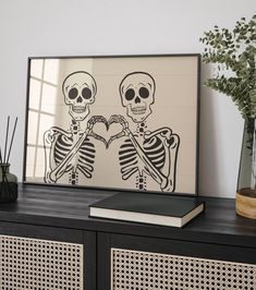 a couple of skeletons holding hands in front of a mirror on top of a dresser