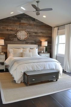 a bedroom with wooden walls and white bedding