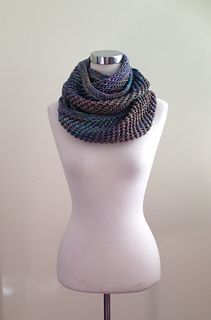 a white mannequin wearing a multicolored knitted scarf on it's neck