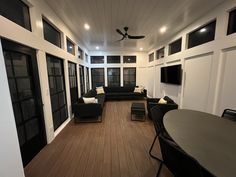 a living room filled with furniture and a flat screen tv mounted on the wall next to a wooden floor