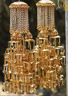 two golden chandeliers hanging from a wooden pole