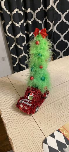 a green christmas tree sitting on top of a wooden table