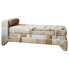 an upholstered chaise lounge with patchwork fabric on the back and sides